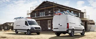 Upfitting vans outside a construction site.